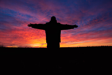 Silhouette of faith amidst a vibrant and colourful sunset in the South Australian desert.