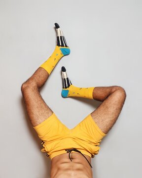 Close-up of sportsmen wearing yellow socks for a funny photoshoot at home.
