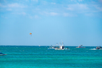 Boracay, Philippines - Jan 20, 2020: Empty White beach of Boracay island in the daytime. No Chinese tourists because of the coronavirus. Boats in the sea carry tourists.