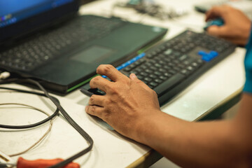 Mano de un profesor enseñando en la computadora