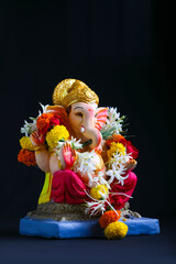 Decorative Lord ganesha sclupture on dark background.