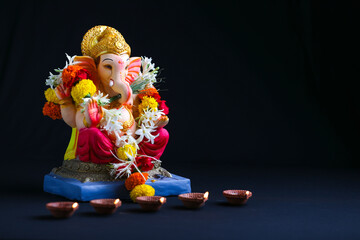 Decorative Lord ganesha sclupture on dark background. - obrazy, fototapety, plakaty