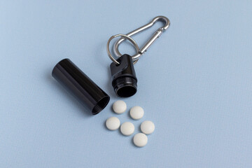 Metal box for medicine and pills on blue background. Pill box connected with a carbine.