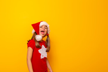 Little girl wearing Santa hat sticking tongue out