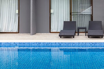 Wide swimming pool and brown stone floor inside the villa