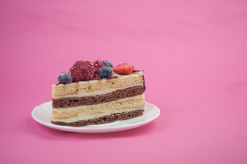 Mix berry slice cake on plate on pink paper background