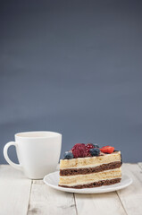 Mix berry cheese cake on white plate on wood background