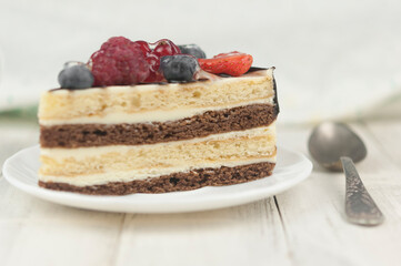 Mix berry cheese cake on white plate on wood background
