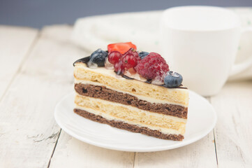 Mix berry cheese cake on white plate on wood background