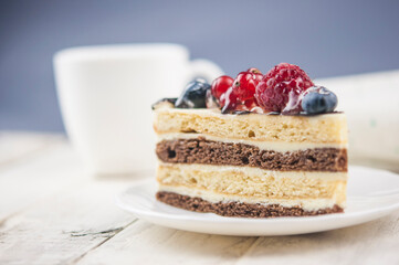 Mix berry cheese cake on white plate on wood background