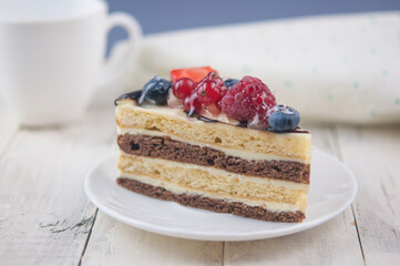 Mix berry cheese cake on white plate on wood background