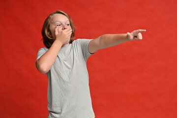 high resolution photo guy teenager surprised covering his mouth with his hand on a red background