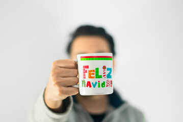 Hombre agarrando taza de feliz navidad