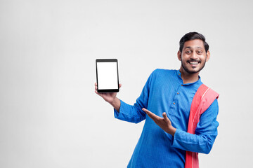 Naklejka na ściany i meble Young indian farmer showing tablet and giving expression on white background.