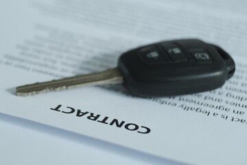 A contract with a car key on the table.