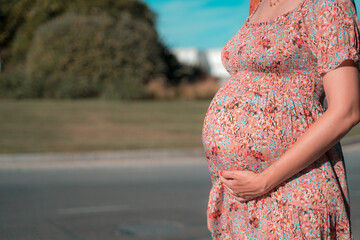 Close up of cute pregnant belly outside in the park