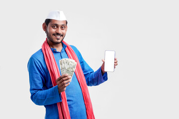 Young indian farmer showing smartphone and money on white background.