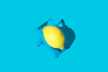 Lemon on blue background in deck chair.
