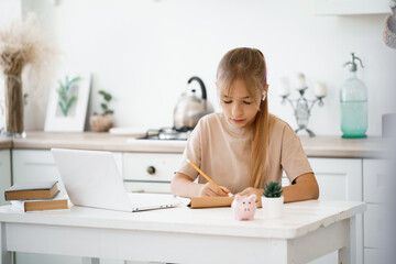 Young girl using laptop for homework at home