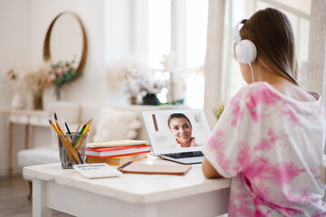 Young girl using laptop for homework at home