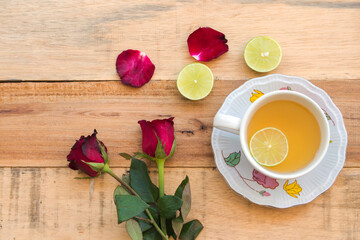 Fototapeta na wymiar herbal healthy drinks honey lemon for health care with red rose flowers arrangement flat lay style on background wooden 
