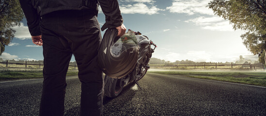 Motorradfahrer mit Motorrad auf einer Landstraße