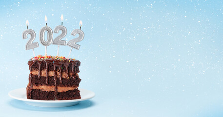 Christmas cake with number 2022 burning candles