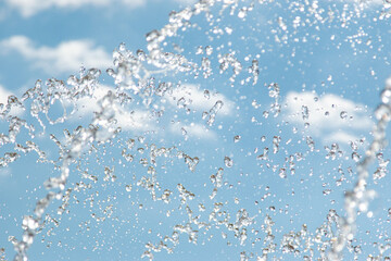 water jet with splashes on the sky background