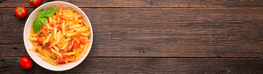 Plate CHERRY TOMATO PASTA Like an Italian on wooden background with copy space banner