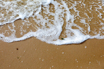 Auf Sand auflaufendes Wasser