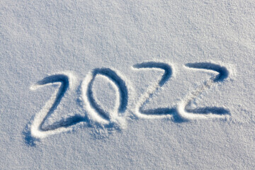 the inscription about the new year 2022 on the snow in winter