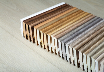 Plastic skirting board with wood texture in various colors. Design and production of flooring and...