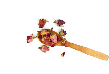 rose flower dry tea in a wooden spoon isolated on a white background. Rose bud tea isolated. Dried Rose Flower Herbal Tea.