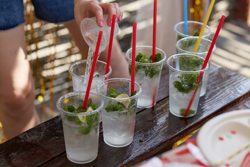 Young woman at a bachelorette party makes a mojito cocktail for the company. Preparation instructions. Step 2