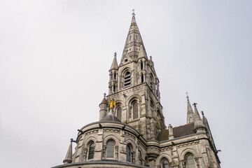 Fototapeta na wymiar towers and golden angel of the cathedral of Cork in the south of ireland a typical gray day of the country