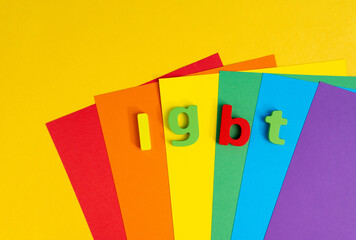 Abbreviation LGBTQ on color background. Top view