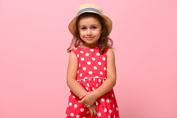 Little child kid baby girl 3-4 years old wearing pink polka dots dress and summer hat , isolated on pink background, children studio portrait. Mother's Day, love family, parenthood childhood concept