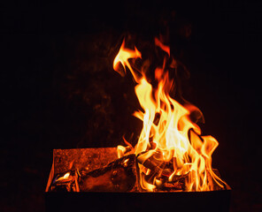 flame of a fire in the grill at night