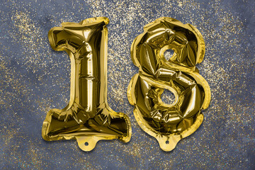 The number of the balloon made of golden foil, the number eighteen on a gray background with sequins. Birthday greeting card with inscription 18. Numerical digit, Celebration event, template.