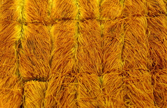 Turkish pastry cake kadaif pieces, traditional sweet. Greek pastry Kataifi with shredded filo dough stuffed with pistachios nuts, in honey syrup.
