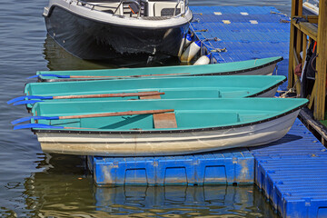 Pleasure rowing boats are stored on a floating platform on a summer day