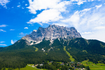 Tyrolean Zugspitze Arena.
Panoramic aerial view at the Zugspitze mountain, the highest mountain in Germany. Seen from Lermoos village. Tourism and vacations concept.