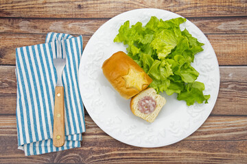 petit saucisson brioché dans une assiette