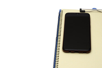 A smartphone on a notebook with white copy space