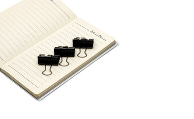 Organized three binder clips on an open notebook with white copy space