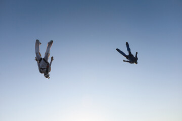Skydiving.  A team of skydivers is in the sky.