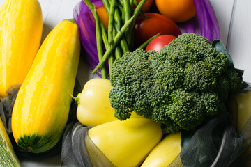 Zero waste, food shopping, eco bags for vegetables and fruits. Vegetables, broccoli close-up, asparagus beans, zucchini, peppers and tomatoes in eco-friendly flat lay bags.