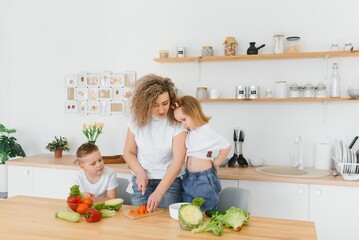 Family in a kitchen. Beautiful mother with children. Lady in white blouse.