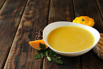 Concept of tasty food with pumpkin soup on wooden table