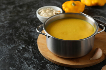 Concept of tasty food with pumpkin soup on black smokey table